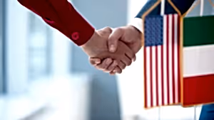 İki kişinin tokalaşması, arka planda ABD ve İtalya bayrakları