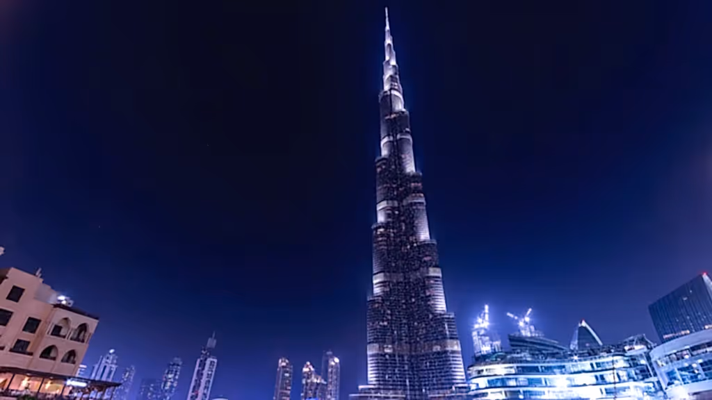 Gece ışıklarıyla aydınlatılmış Burj Khalifa, Dubai'nin şehir silüetinde yükseliyor