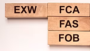 Ahşap bloklar üzerinde EXW, FCA, FAS ve FOB terimleri, uluslararası ticarette kullanılan Incoterms kurallarını temsil ediyor.