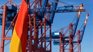 Almanya bayrağı ön planda, arka planda büyük yük vinçleri ve konteyner terminali