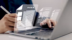 Dijital belgelerle çalışan bir kişi, dizüstü bilgisayar ekranında belge düzenliyor